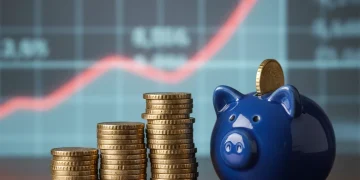 Piles de pièces d'euros et tirelire, symbolisant l'épargne et les taux d'intérêt